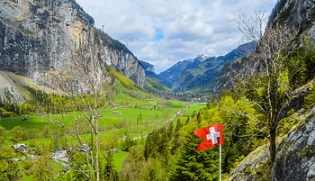 Swiss landscape, lush valley, national flag, picturesque view, village in valley, Swiss flag, mountain valley, green valley, Swiss countryside, alpine scenery, Swiss alps