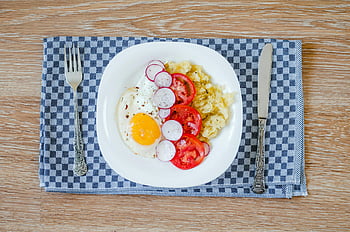 egg with vegetable dish, fried eggs, tomatoes, radishes, smashed potatoes, breakfast, delicious, plate, wooden table, silverware, checkered placemat