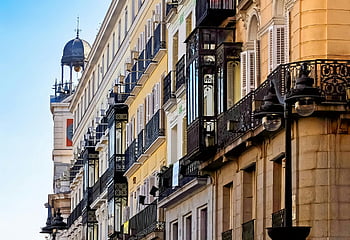 apartment buildings, Madrid street scene, elegant historic buildings, ornate balconies, vibrant Madrid, historic architecture, cityscape, urban scene, European city, street view, blue sky