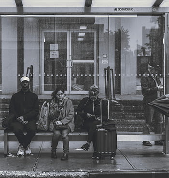 sitting on bench, bus stop, New York, urban life, travel, waiting, city, public transportation, street scene, commuters, luggage