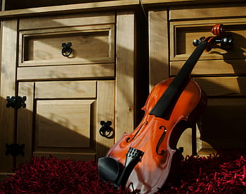 violino marrone, mobile in legno, tappeto rosso, ombre drammatiche, cassetti di legno, violino meravigliosamente realizzato, tappeto strutturato, strumento musicale, arredamento interno, mobili classici, illuminazione artistica