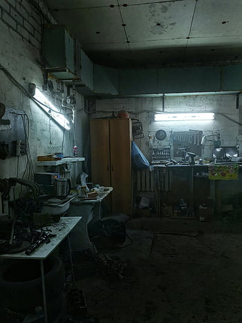 Here are the most relevant photo keywords for SEO based on the provided caption, description, and the photo:

workshop, fluorescent lighting, cluttered workshop, tools and machinery, dimly lit workshop, industrial setting, workshop organization, workshop equipment, workshop interior