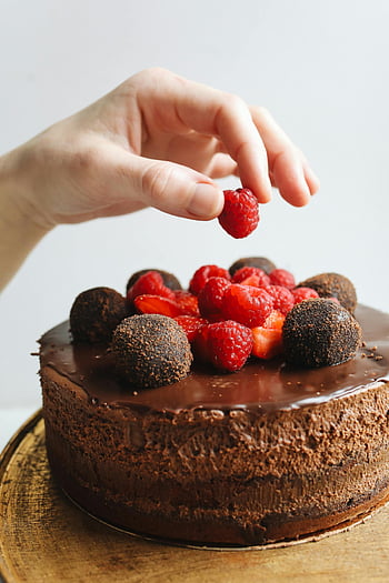 chocolate cake, raspberries, truffles, hand decorating, close-up, dessert, fruit topping, sweet treat, gourmet cake, baking, confectionery