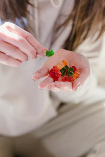 barevné gumové bonbóny, rozmanité gumoví medvědi, sladké dobroty, žena držící bonbóny, barevné marmelády, ruka držící gumové bonbóny, různé bonbóny, sortiment gumových bonbónů, Barevné bonbóny, sladké bonbóny, gumoví medvídci