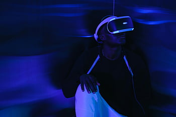 vr headset, realitas virtual, Pria sedang bermain game, Pengaturan futuristik, menjelajahi dunia virtual, pengalaman mendalam, pencahayaan biru, Teknologi Gaming, lingkungan virtual, Permainan interaktif, teknologi futuristik