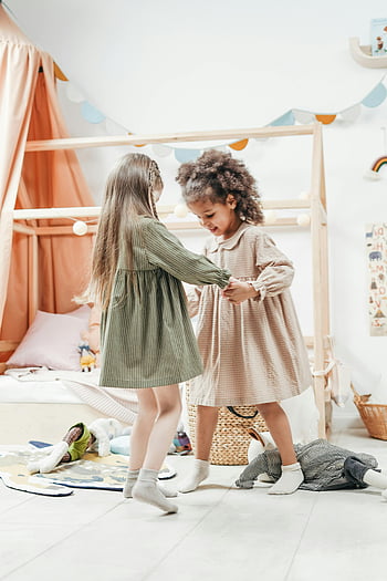 girls dancing, young girls, cozy playroom, childhood friendship, joy, indoor play, children's room, playful moment, kids activity, dance together, fun times