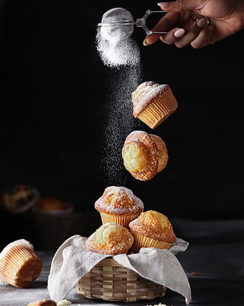 muffiny, Oprášení cukru, Kulinářská jemnost, Sladká shovívavost, detail, práškového cukru, pečené dobroty, Dezertní fotografie, styling potravin, Muffinový koš, černé pozadí