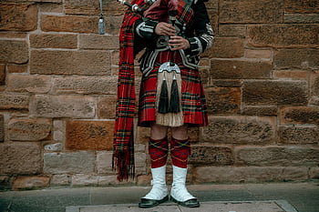 Scottish bagpipe player, traditional attire, kilt, stone wall, tartan, bagpipes, Scottish culture, traditional clothing, Scottish music, cultural attire, Scottish heritage