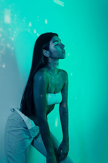 Mladá žena, dlouhé vlasy, neonové světlo, zářivé osvětlení, moderní styl, elegantní pozice, Neon Room, stylová žena, současná móda, Neonová atmosféra, vnitřní portrét