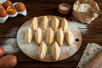 Knödel, rundes Tablett, frisch zubereitet, traditioneller Pierogis, Mehlbrett, bereit zum kochen, Eier, Mehl, Holztisch, Kartoffeln, Kücheneinstellung
