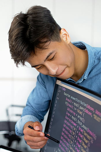 若者、 プログラミング、 近代的なオフィス、 ほほえむ、 モニターを指差して、 コード、 コンピューターの画面、 カジュアルな服装、 作業環境、 技術、 プロの環境
