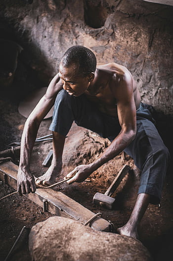 hardworking man, blacksmith, crafting metalwork, dimly lit workshop, skill, tradition, focused, workshop, metalwork, blacksmithing, craftsmanship