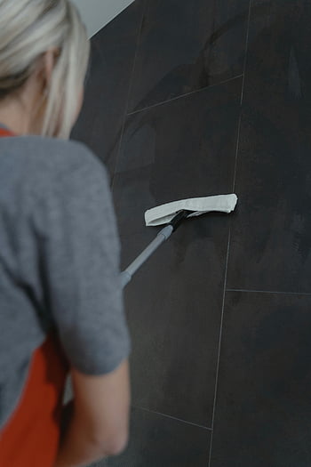 woman cleaning, dark wall, mop, modern home cleaning, close-up, cleaning methods, tiled wall, indoor cleaning, household chores, cleaning tools, woman mopping