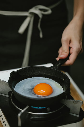 Koch, Ei braten, gusseiserne Pfanne, Gasherd, Kochen, Küche, Essenszubereitung, Eigelb, Pfanne kochen, Küchenchef Hände, Schürze