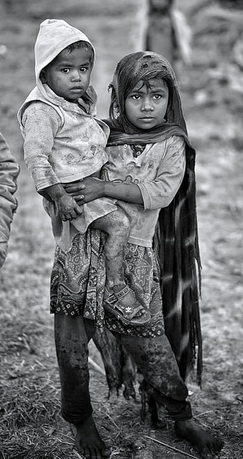 rural Sindh, Pakistan, young children, hardship, resilience, boy carrying brother, rural life, poverty, childhood, black and white, siblings