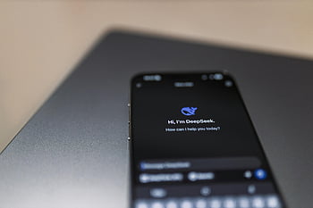 smartphone display, AI assistant interface, close-up smartphone, laptop background, DeepSeek AI, mobile AI interface, digital assistant, smart device screen, technology interface, AI chatbot, smartphone technology