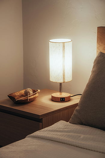 lamp on nightstand, warm bedroom scene, glowing lamp, wooden nightstand, cozy bedroom, bedside lamp, nightstand decor, bedroom lighting, modern nightstand, ambient lighting, bedroom ambiance
