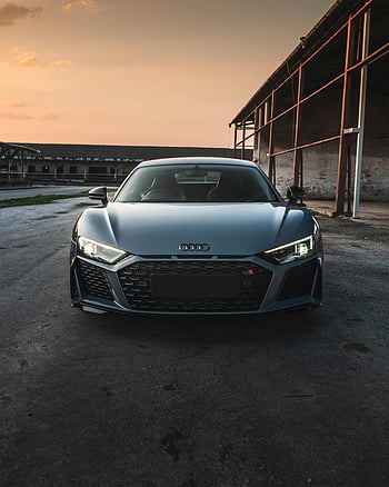 Audi R8, silver car, parked on street, urban setting, sunset, front view, sleek supercar, elegant parking, car photography, automotive design, luxury vehicle