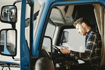 Muž v kostkované košili, sedí v kamionu, Čtení papírů, modré auto, kabina nákladního auta, mužský mechanik, kontrolní seznam, zaměřené, vážné, Interiér kamionu, kostkovaná košile