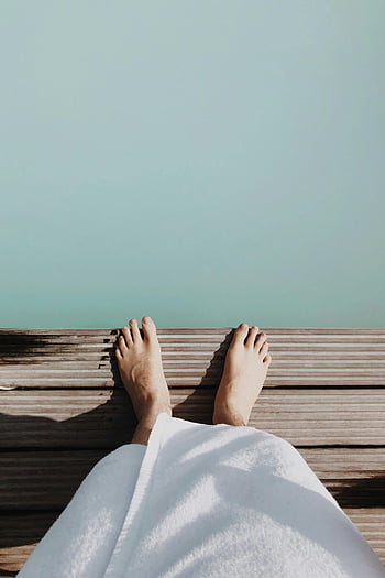 men's white towel, geothermal spa, Reykjavik, relaxing, serene view, wooden deck, feet, spa relaxation, outdoor spa, Iceland, wellness