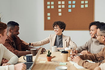 happy colleagues, collaborative meeting, modern office, business professionals, sharing ideas, smiling team, office setting, group discussion, professional collaboration, workplace interaction, team meeting