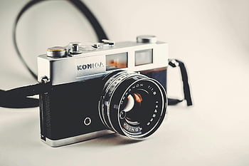 vintage Konica camera, classic design, lens details, gray and black, disposable camera, sleek design, retro camera, Konica Hexanon, vintage photography, classic camera, camera strap