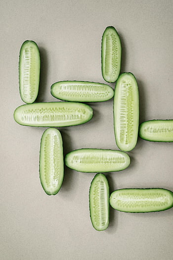 cucumbers, sliced cucumbers, geometric patterns, top view, fresh cucumbers, neatly arranged, cucumber slices, half cucumbers, green vegetables, food photography, healthy food