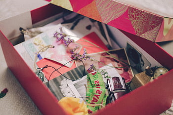 colorful box, photographs, papers, sentimental items, nostalgia, assorted pictures, memory box, keepsakes, vintage photos, decorative box, personal mementos