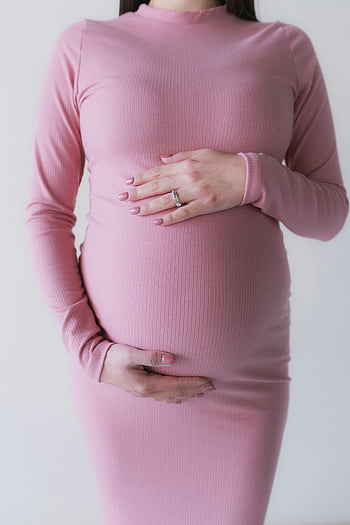 gravid kvinne, rosa kjole, barselportrett, baby bump, omfavner, vakker, barselmote, graviditetsstil, gravid mote, Fødselspermisjon, rosa gravidkjole