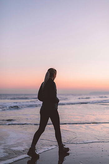 woman walking, beach, sunset, ocean, tranquil scenery, seaside, evening walk, coastal view, female silhouette, peaceful moment, seaside stroll