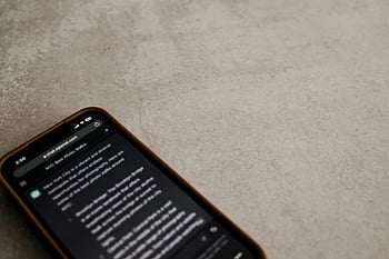 smartphone, chat interface, ChatGPT, close-up, textured surface, conversation, mobile device, digital chat, AI chatbot, screen display, smartphone screen