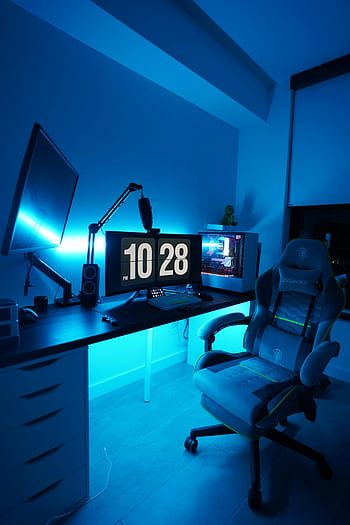 Spielzimmer, blaues Licht, zwei Monitore, Gaming-Stuhl, Arbeitsplatz, gut beleuchtet, gemütlich, Spieler, Spiel-Setup, Schreibtisch, Computer