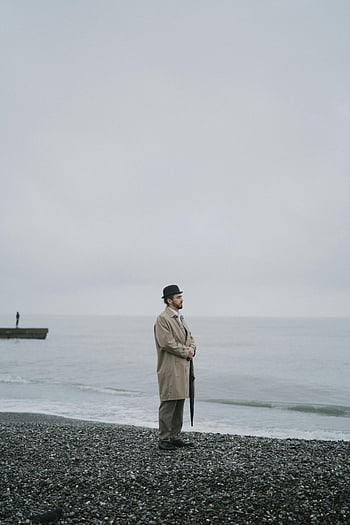 茶色のコートの男、 海岸、 霧の雰囲気、 不機嫌そうなシーン、 内省的なムード、 一人の男、 ビーチ、 オーシャンビュー、 小石のビーチ、 帽子をかぶった男、 傘