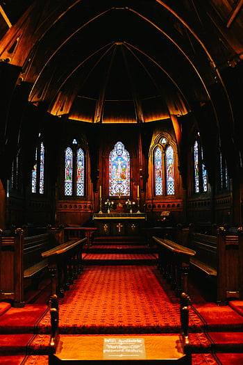 interior da igreja, arquitetura gótica, vitrais, calorosamente iluminados, cores vibrantes, espaço religioso, bancos de madeira, área do altar, ambiente espiritual, design de interiores, igreja histórica