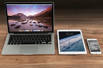 Macbook Pro, White iPad, Apple laptop, tablet, smartphone, wooden desk, modern workspace, Apple devices, tech setup, office gadgets, digital workspace
