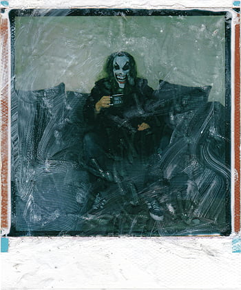 polaroid fotografie, Muž s obličejem Joker, sedí na gauči, strašidelná postava, Joker Makeup, Vintage polaroid styl, gauč, Foto titulek, Popis fotografie, Polaroid styl, strašidelný