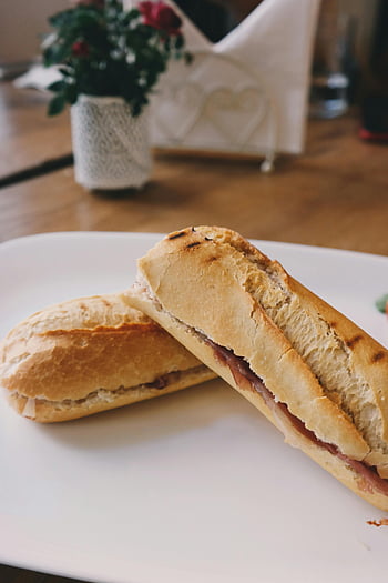 bread, white ceramic plate, baguette sandwich, ham, cozy setting, delicious, white plate, sandwich, baguette, ham sandwich, cozy