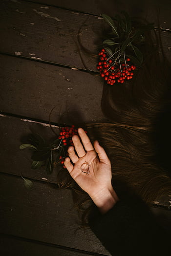 zilveren ring, handpalm van de persoon, rode bessen, houten oppervlak, creatieve compositie, hand vasthoudende ring, sieraden fotografie, stilleven, natuurlijke elementen, Minimalistische kunst, rustieke achtergrond
