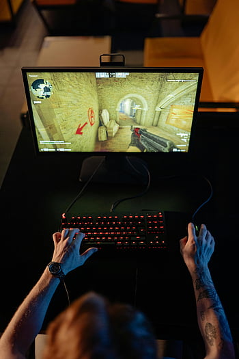 gamer, video game, computer, glowing keyboard, top view, playing game, gaming setup, computer monitor, gaming mouse, tattooed arms, wristwatch