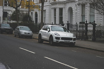 parked cars, residential street, urban setting, classic architecture, quiet street, white SUV, parked vehicles, street parking, urban residential, classic building, quiet neighborhood