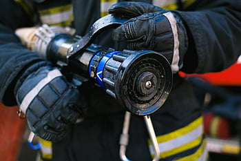 firefighter, holding hose, water hose nozzle, firefighter gear, safety, emergency readiness, close-up, detailed, gloves, uniform, hose nozzle