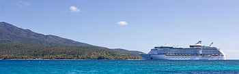 white cruise ship, tropical island, vibrant blue sky, ocean, large cruise ship, lush island, cruise ship near island, blue ocean, tropical scenery, cruise ship, island view