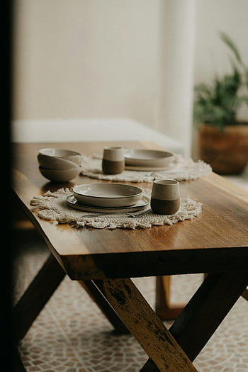 Geschirr auf dem Tisch, Keramikplatten, erdige Töne, Innentischeinstellung, Holztisch, Tassen, Tischsets, Ess-Setup, rustikales Geschirr, gemütliches Essen, Wohnkultur