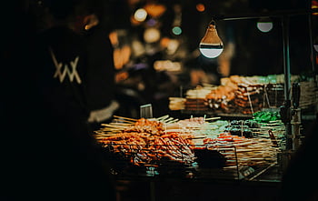 špízy, gril, živé pouliční jídlo, živý noční trh, teplé osvětlení, špejle, noční trh, pouliční jídlo, grilovaná masa, stánek s jídlem, noční scénu