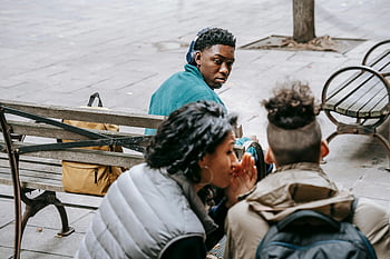 nicht erkennbare Freunde, klatschen, Straße, junge Erwachsene, unterhalten, Parkbank, Geheimnisse teilen, Vertrauen aufbauen, Outdoor-Einstellung, lässige Interaktion, soziale Verbindung