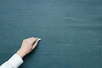 person holding chalk, white chalk, blank blackboard, hand writing, chalkboard surface, education, classroom, teaching, writing tool, school supplies, learning
