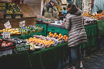 city market, fresh fruits, diverse fruits, market stall, customer browsing, lively market, fruit display, assorted fruits, outdoor market, fruit stand, city shopping