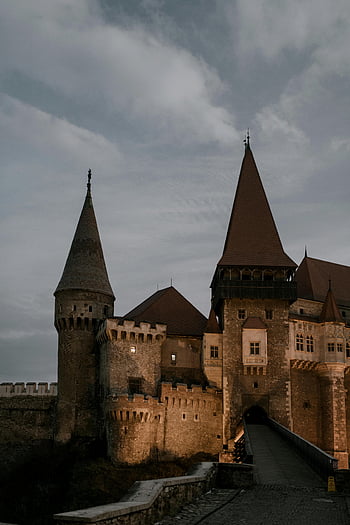 Medieval stone castle, Corvin Castle, Hunedoara, Romania, gloomy sky, dramatic architecture, twilight, stone fortress, medieval architecture, castle towers, historic landmark
