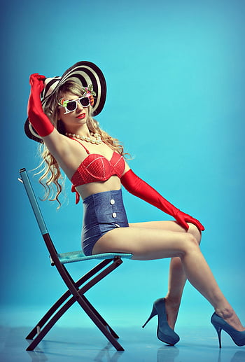 Žena sedí na židli, Okouzlující žena, Styl pin-up, retro móda, modrá židle, červené rukavice, sluneční brýle, čepice, vysoké podpatky, džínové sukně, perlový náhrdelník