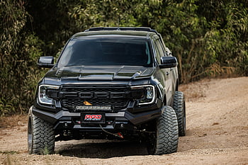 Černá 4x4 Ford, terénní kamion, drsná špinavá cesta, svěží zeleň, vysoký výkon, černá terénní, ford truck, jízda v terénu, 4x4 vozidlo, venkovní dobrodružství, Výkon kamionu